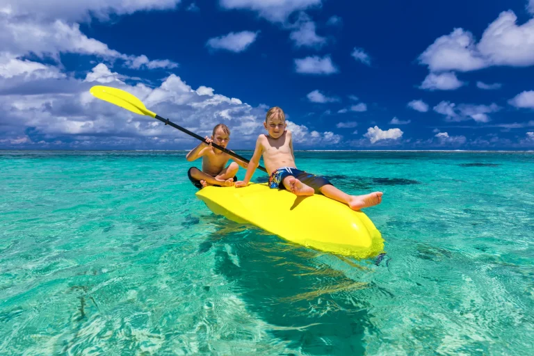 vacancesguadeloupe__two-young-caucasian-boys-kayaking-at-tropical-sea-2026-03-15-23-27-32-utc