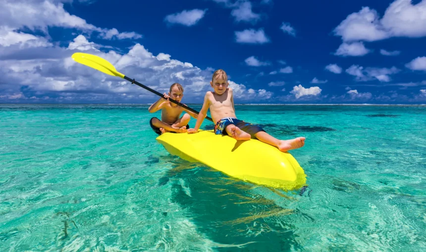 vacancesguadeloupe__two-young-caucasian-boys-kayaking-at-tropical-sea-2026-03-15-23-27-32-utc
